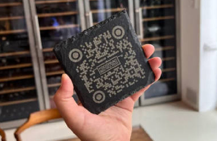 Real User Stories: Hand holding a laser-engraved stone gift (with QR code design) from Rianna and Calvin's Laser Engraving Studio; the studio uses LaserPecker LP5 to create custom engraved gifts for new restaurant openings to build brand recognition.