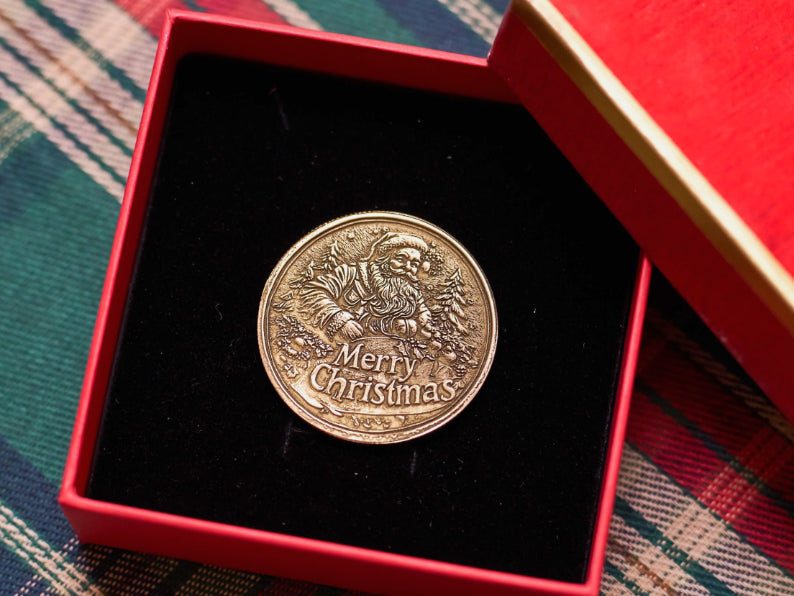 Finished laser-engraved "Merry Christmas" metal coin presented in a red gift box, showcasing the final polished result of LaserPecker LP5's engraving workflow.
