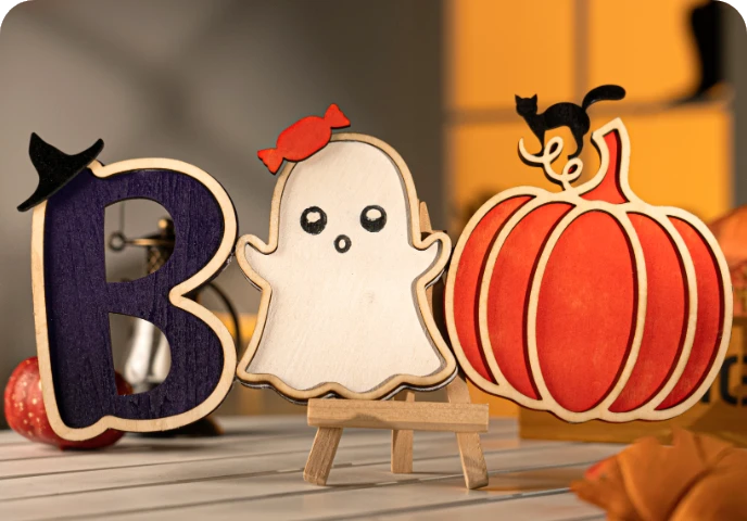 Wooden seasonal ornaments showcased in a Halloween setting.