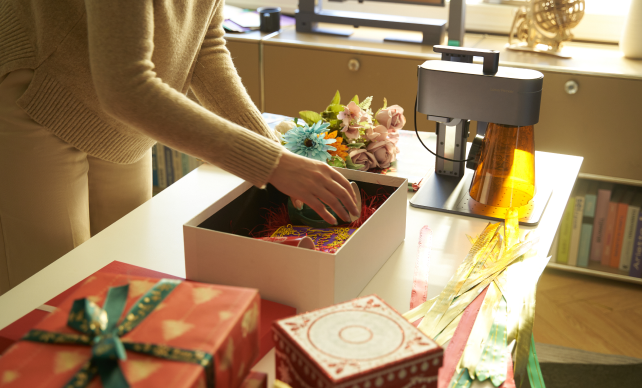 A woman packing various engraved products into a gift box.