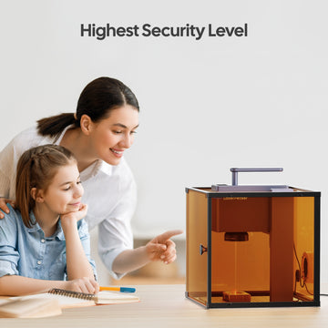 LaserPecker engraver in an amber safety enclosure, demonstrating its highest security level for safe family use, with a parent and child observing the engraving process.